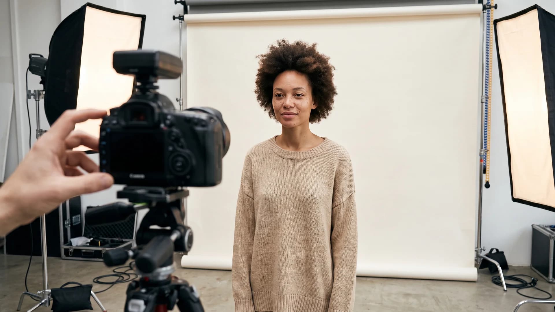 Fashion logo design carried into a consistent studio product photo shoot of a model in a neutral sweater